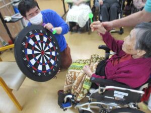 ケアホーム俊徳道　ボランティア訪問　ダーツ体験・絵本クラブ・音真似パフォーマー
